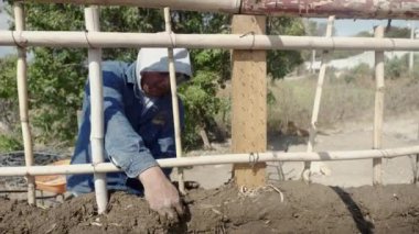 a man building a wall with bioconstruction techniques