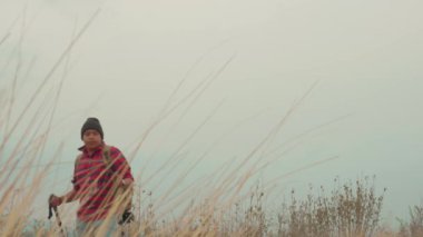 a young man wearing jacket and backpack on trek trip outdoor in mountains. High quality 4k footage