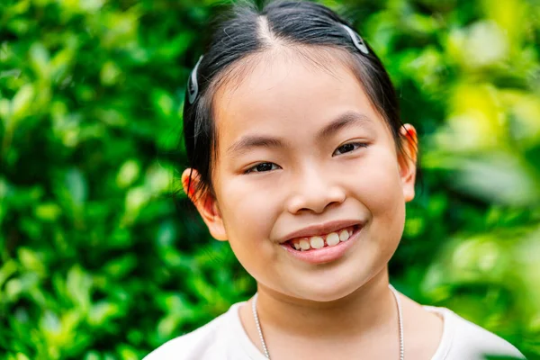 세에서 사이의 귀엽고 아시아인 소녀가 얼굴을 맞대고 웃으며 카메라를 정원의 — 스톡 사진