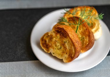 Restoranda beyaz bir tabakta sarımsaklı lezzetli ekmek, sarımsaklı çıtır ekmek..