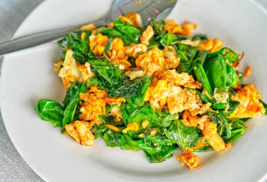 Yakın çekim Tayland yemekleri sağlıklı menü, kızarmış Malindjo yaprakları tavuk yumurtaları, doğal gün ışığı.