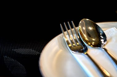 Lokantadaki beyaz bir tabakta kaşığı ve çatalı yakın plan, mesaj için boşluk..