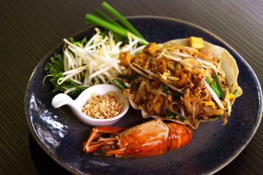 Güzel Pad Thai 'yi kapatın, siyah masa üzerinde güzel bir dekorasyon, özel menü Pad Thai ve büyük bir karides..