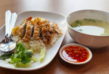 Kızarmış pirinç ya da Tayland dilinde Kaw Mon Kaitodd. Bol yağda kızartılmış tavuk pilavı ve tatlı soslu Tayland-Çin yemeği menüsü, temiz çorba. Doğal ışık ile gerçek görüntü.