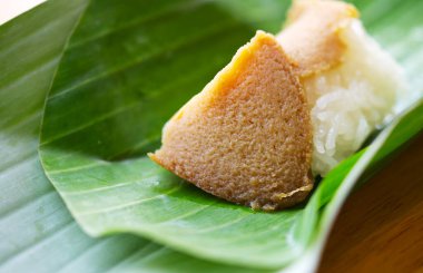 Geleneksel Tayland tatlı menüsü, muz yaprağı paketinde balkabağı kremalı yapışkan pirinç, doğal ışık, yakın çekim yiyecek görüntüsü, balkabağı kremasına odaklanma.