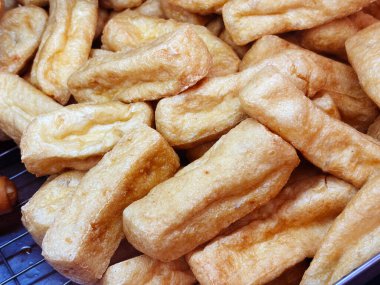 Sağlıklı Asya yemeği, bol yağda kızartılmış tofu. Tayland 'da bir yiyecek pazarında tepside kızartılmış tofu yığını..