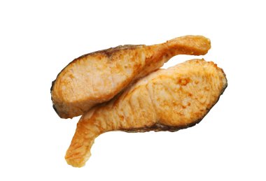 Beyaz arka planda iki parça kızarmış somon balığı. Üst tarafta da dilimlenmiş somon eti..