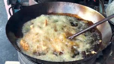 Büyük bir tavada kaynar yağ. Tayland sokak yemeklerinde kızarmış tavuk..
