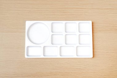 Beyaz suluboya palet. Boş suluboya tepsisi ahşap arka planda izole edilmiş. Beyaz plastik boya paleti.