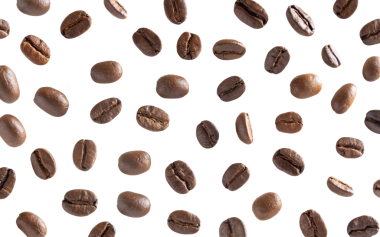 Kavrulmuş kahve çekirdeği. Kesme yolları olan beyaz bir arka planda kahve çekirdekleri. Kapat..