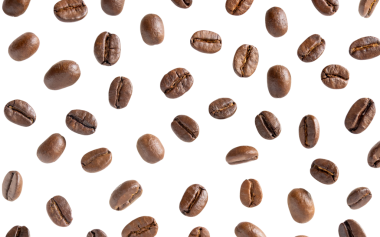 Kavrulmuş kahve çekirdeği. Kesme yolları olan beyaz bir arka planda kahve çekirdekleri. Kapat..