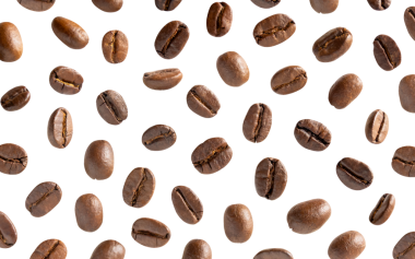 Kavrulmuş kahve çekirdeği. Kesme yolları olan beyaz bir arka planda kahve çekirdekleri. Kapat..