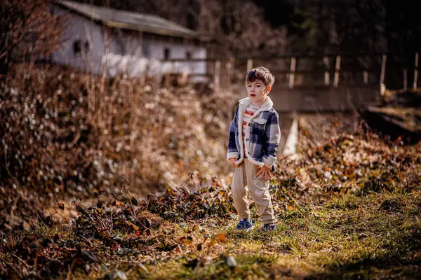 Üzgün küçük bir çocuk dışarıda kirli elleriyle duruyor, doğada oynadıktan sonra hayal kırıklığına uğramış görünüyor..