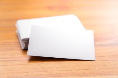 Boş maket (kartvizit) ve tahta arka planda bir fincan kahve. Tasarım için hazırlan.