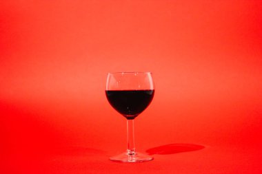 kırmızı bir arka plan üzerinde kırmızı şarap cam