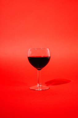 kırmızı bir arka plan üzerinde kırmızı şarap cam