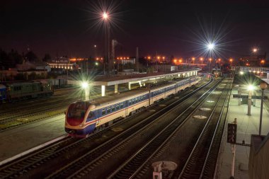 Platform yakınında yolcu treni olan gece tren istasyonu manzarası. Demiryolu manzarası. Yukarıdan görüntüle 