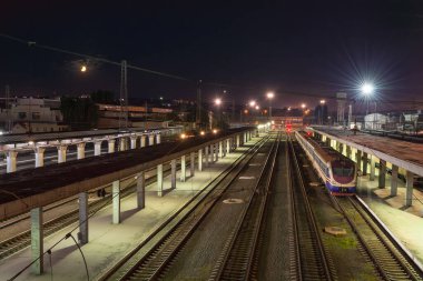 Yolcu treni platformun yakınında olan gece tren istasyonu manzarası. Demiryolu manzarası. Yukarıdan görüntüle 