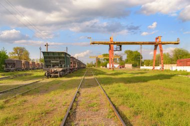 Güneşli bir günde yoğun yeşil çimlerle kaplanmış eski tren istasyonu. 