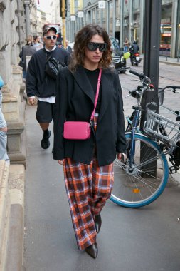 MILAN, İTALYA 21 Eylül 2022: Kareli pantolonlu, siyah ceketli ve pembe deri çantalı kadın Calcaterra moda defilesinden önce, Milan Moda Haftası tarzı