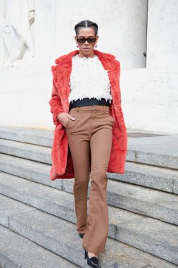 MİLAN, İTALYA 22 Eylül 2022: kırmızı kürk ceketli ve bej pantolonlu konuk Max Mara moda defilesinden önce, Milan Moda Haftası tarzı