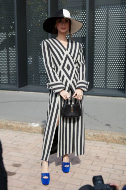 MİLAN, İTALYA 23 Eylül 2022 Gucci moda defilesinden önce gri ve siyah çizgili elbiseli kadın, Milan Moda Haftası tarzı