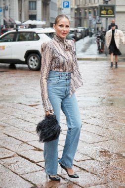 MILAN, İTALYA 24 EPTEMBER 2022: Mavi kot pantolonlu ve zincir dizaynlı ipek gömlekli kadın Lorenzo Serafini moda defilesi, Milan Moda Haftası tarzı