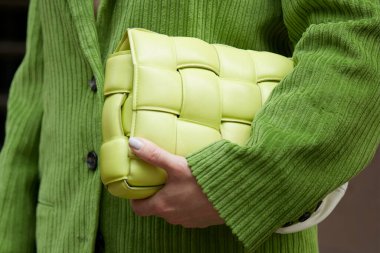 MILAN, ITALY - SEPTEMBER 25, 2022: Woman with green velvet jacket and leather bag before Luisa Spagnoli fashion show, Milan Fashion Week street style