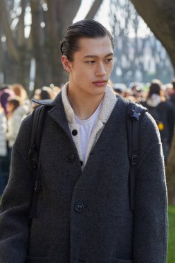MILAN, ITALY - JANUARY 14, 2023: Man with gray coat before Emporio Armani fashion show, Milan Fashion Week street style