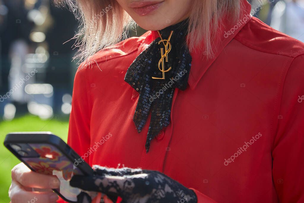 MILAN, ITALY - JANUARY 14, 2023: Woman with black sequin ribbon with golden Yves Saint Laurent logo before Emporio Armani fashion show, Milan Fashion Week street style