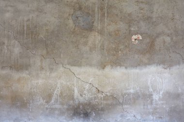 Gray concrete wall with cracks and white stains texture background 