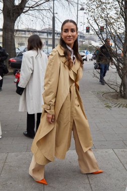 MILAN, İtalya - 22 Şubat 2023: Bej rengi trençkotlu ve turuncu ayakkabılı Tamara Kalinic Alberta Ferretti moda defilesinden önce, Milan Moda Haftası tarzı