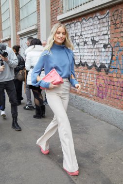 MILAN, İtalya - 22 Şubat 2023: Victoria Magrath mavi gömlekli, Fendi defilesinden önce pembe Fendi çantalı ve bej pantolonlu, Milan Moda Haftası tarzı