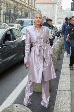 MİLAN, İTALYA 23 Şubat 2023: açık pembe metalik trençkot ve pantolonlu kadın Genny moda defilesinden önce, Milan Moda Haftası tarzı