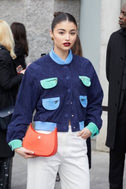 MILAN, İtalya - 23 Şubat 2023: Emporio Armani defilesinden önce yeşil ve açık mavi cepli ve turuncu çantalı kadın, Milan Moda Haftası tarzı