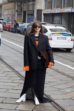 MILAN, İtalya - 24 Şubat 2023: Sportmax defilesinden önce siyah ceketli ve turuncu gömlekli kadın, Milan Moda Haftası tarzı