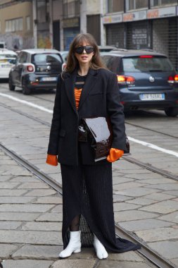 MILAN, İtalya - 24 Şubat 2023: Sportmax defilesinden önce siyah ceketli ve turuncu gömlekli kadın, Milan Moda Haftası tarzı