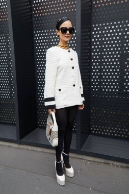 MILAN, ITALY - FEBRUARY 24, 2023: Woman with white jacket and shoes before Gucci fashion show, Milan Fashion Week street style clipart