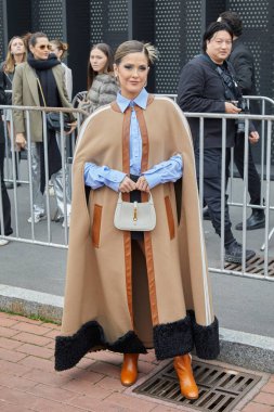 MILAN, İtalya - 24 Şubat 2023: Gucci moda defilesinden önce bej pelerinli ve mavi gömlekli kadın, Milan Moda Haftası tarzı