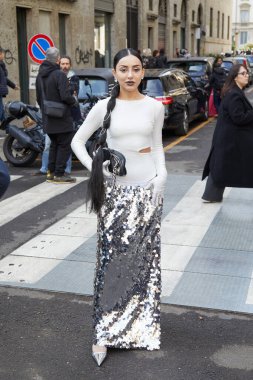 MILAN, İtalya - 25 Şubat 2023: Dolce ve Gabbana defilesinden önce beyaz gömlekli ve gümüş pullu etekli kadın, Milan Moda Haftası tarzı