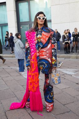 MILAN, İTALYA - 25 Şubat 2023: Kırmızı ve mavi soyut tasarım ceket ve şort ve pembe atkısı olan kadın Missoni defilesinden önce, Milan Moda Haftası stili