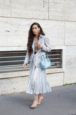 MILAN, İtalya - 25 Şubat 2023: açık mavi çantalı, gümüş pileli etekli ve gri ceketli kadın Missoni defilesinden önce, Milan Moda Haftası tarzı