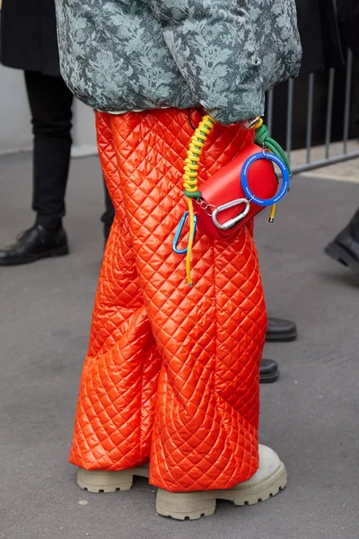 MILAN, İtalya - 14 Ocak 2024: K-Way defilesinden önce kırmızı Alexandre Pavao çantası ve turuncu örtülü pantolonu olan adam, Milan Moda Haftası tarzı