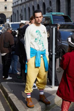 MILAN, İTALYA - 21 Şubat 2024: Sarı pantolonlu ve beyaz gömlekli adam Onitsuka Tiger defilesinden önce, Milan Moda Haftası tarzı