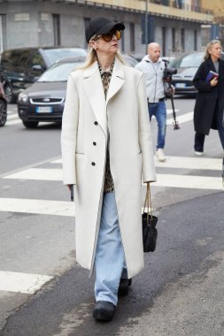 MILAN, İtalya - 22 Şubat 2024: Max Mara moda defilesinden önce beyaz ceketli ve mavi kot pantolonlu kadın, Milan Moda Haftası tarzı