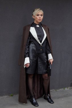 MILAN, İTALYA - 22 Şubat 2024: Kahverengi ceketli ve siyah deri şortlu kadın Max Mara moda defilesinden önce, Milan Moda Haftası tarzı