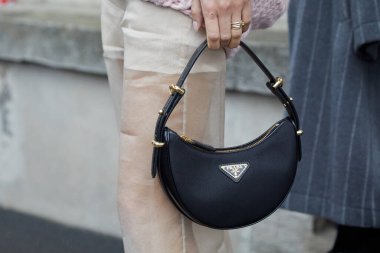 MILAN, İTALYA - 22 Şubat 2024: Prada defilesinden önce siyah Prada çantalı ve bej şifon pantolonlu kadın, Milan Moda Haftası tarzı