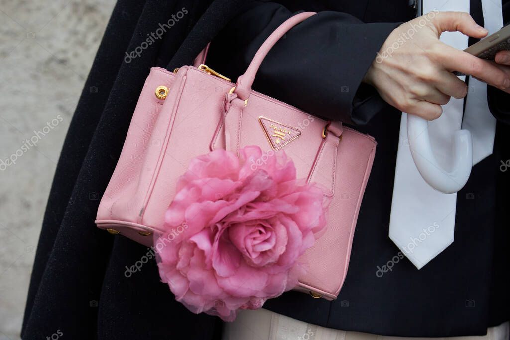 MILAN, ITALY - FEBRUARY 22, 2024: Woman with pink leather Prada bag before Prada fashion show, Milan Fashion Week street style