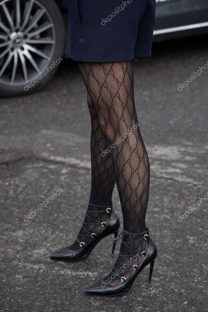 MILAN, ITALY - FEBRUARY 23 , 2024: Woman with Gucci logo stockings before Gucci fashion show, Milan Fashion Week street style