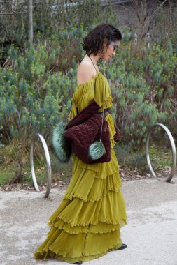 MILAN, İtalya - 24 Şubat 2024: Sarı yeşil elbiseli kadın Ferragamo defilesinden önce, Milan Moda Haftası tarzı